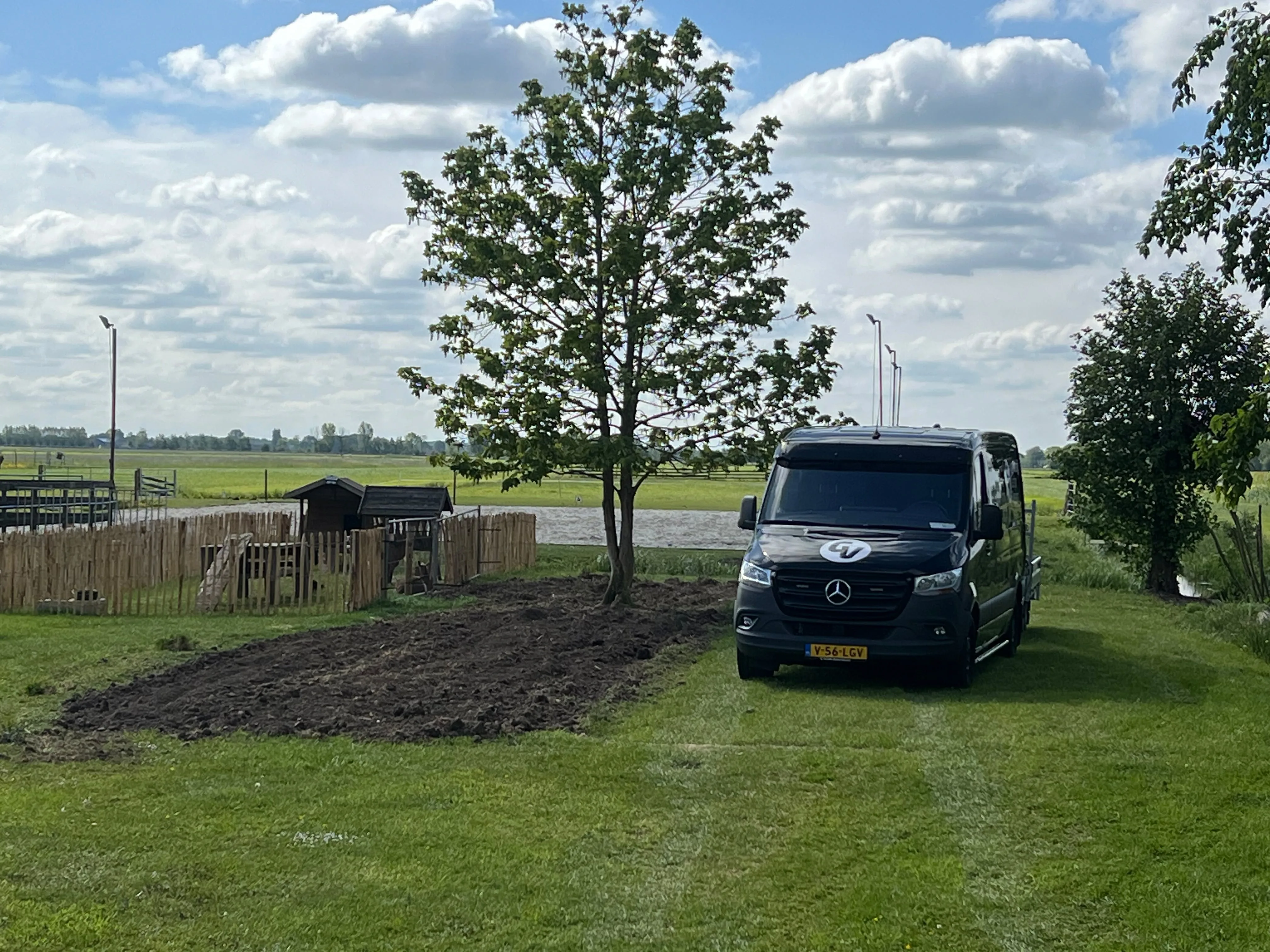 Bedrijfsbus met minishovel op aanhanger